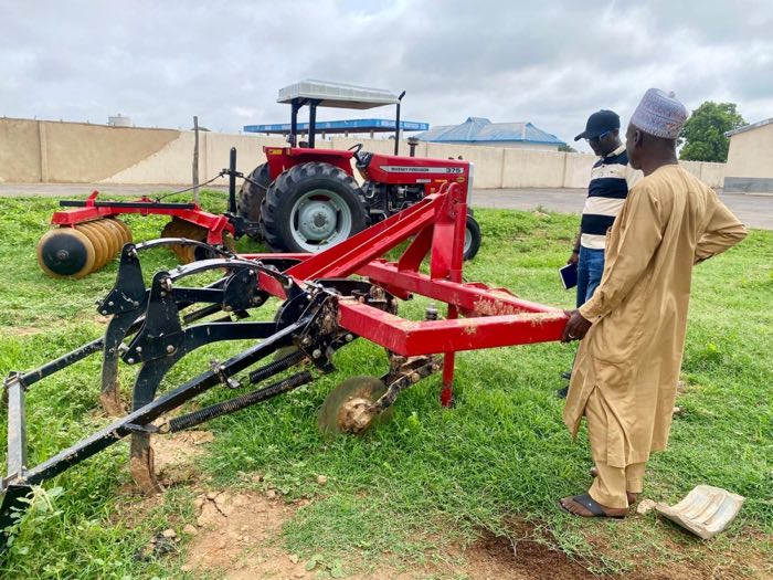 A tractor and farm implement during a field demonstration
